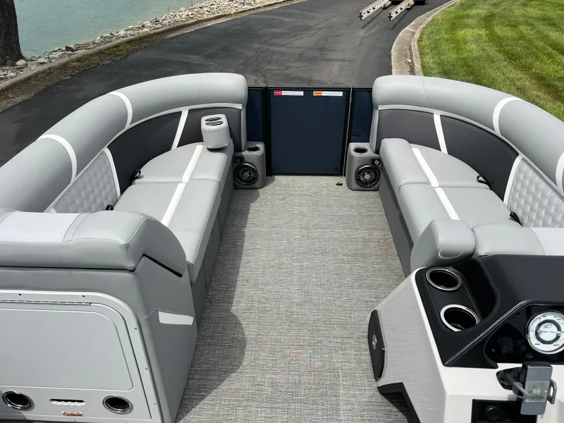 Slide: The Image of 2025 Crest Classic 220 SLRC pontoon boat interior with gray seating and modern dashboard. - 22