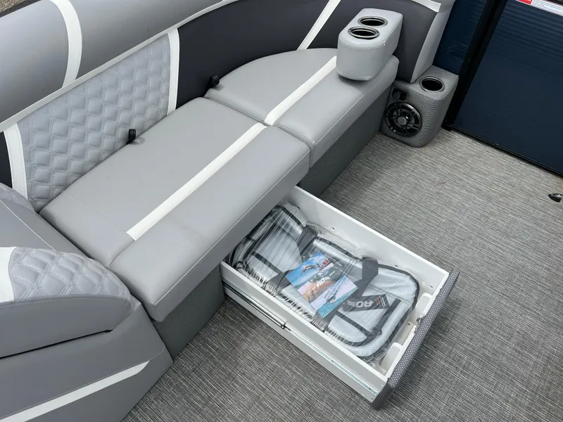 Slide: The Image of 2025 Crest Classic 220 SLRC boat interior with storage drawer and cup holders. - 23