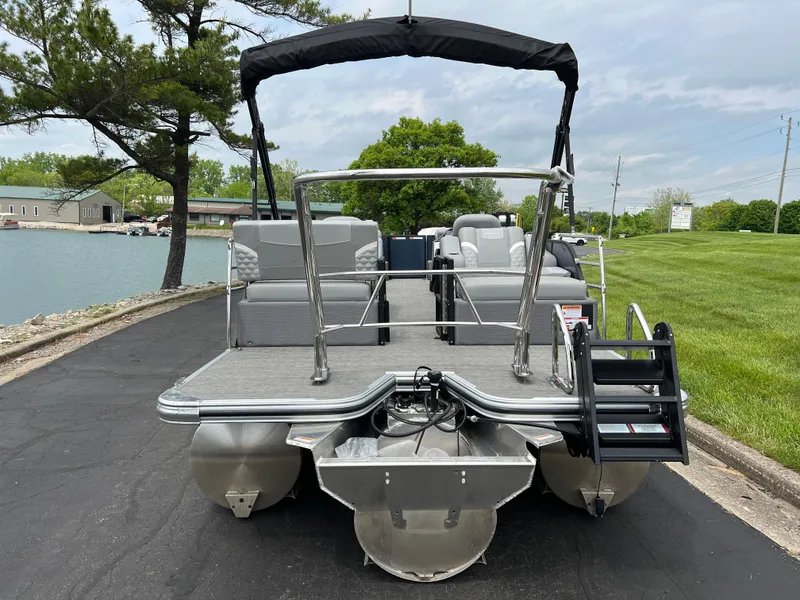 Slide: The Image of 2025 Crest Classic 220 SLRC pontoon boat docked by a lakeside. - 6