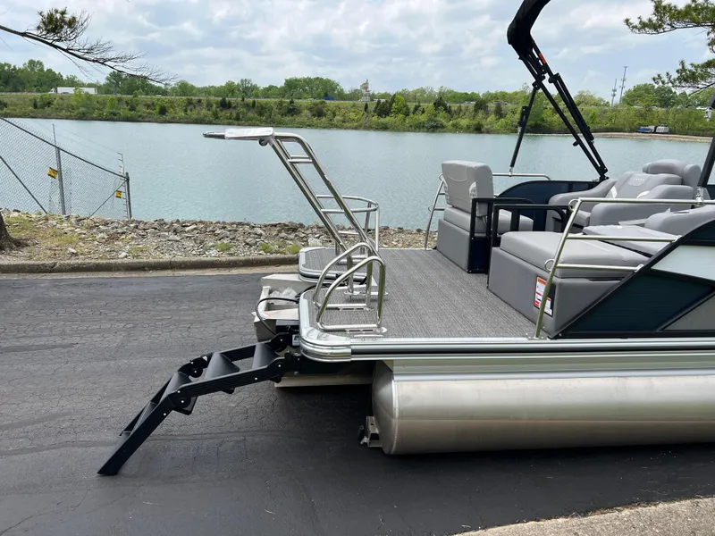 Slide: The Image of 2025 Crest Classic 220 SLRC pontoon boat docked by a serene lake. - 7