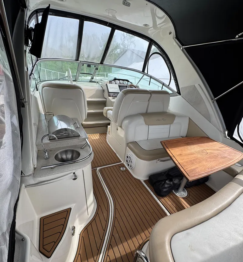 Slide: The Image of 2008 Sea Ray 330 Sundancer interior with seating, table, and helm, featuring sleek design and wood accents. - 14