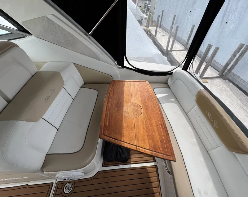 Slide: The Image of 2008 Sea Ray 330 Sundancer interior with wooden table and cushioned seating. - 16