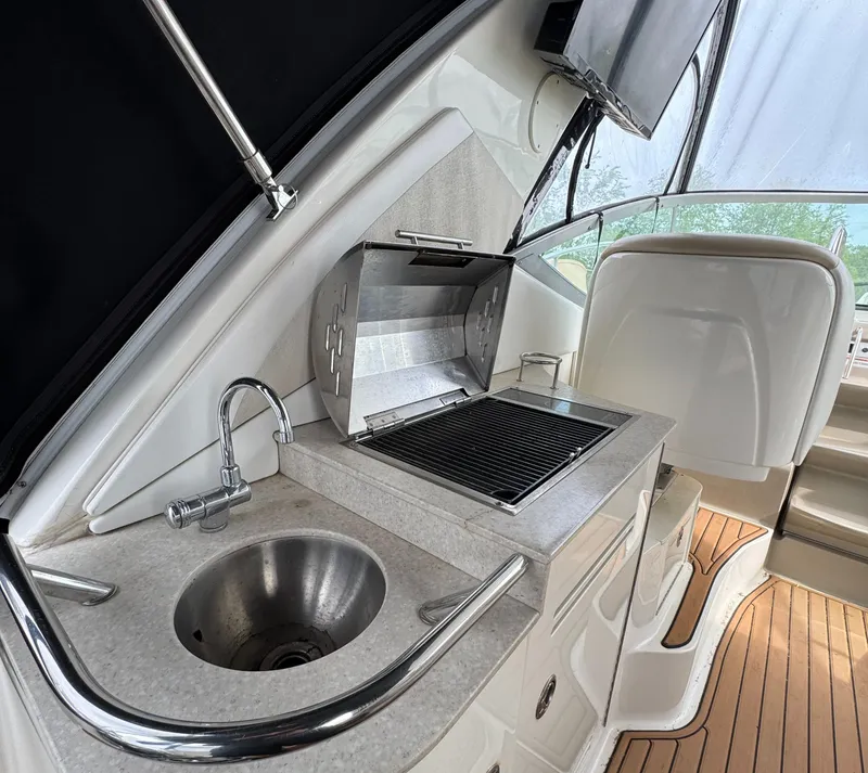 Slide: The Image of 2008 Sea Ray 330 Sundancer boat interior with sink and grill on deck. - 17