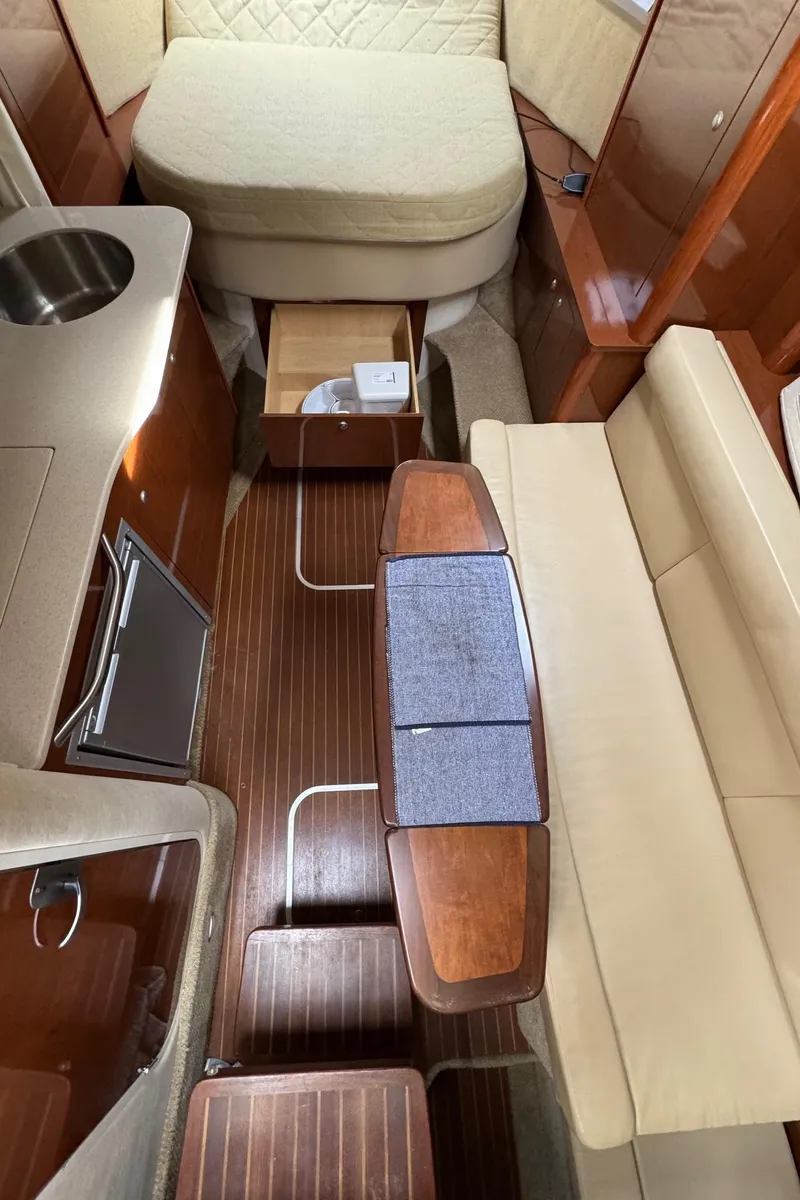Slide: The Image of 2008 Sea Ray 330 Sundancer interior with wood flooring, kitchenette, and seating area. - 9