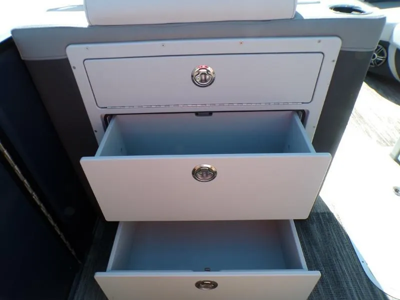 Slide: The Image of Open storage drawers on a 2025 Godfrey AquaPatio 255 SFL iMPACT boat. - 5