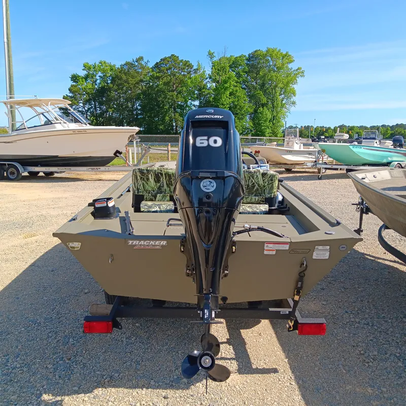 Slide: The Image of 2025 Tracker Grizzly 1754 SC boat with Mercury 60 engine, parked outdoors. - 3