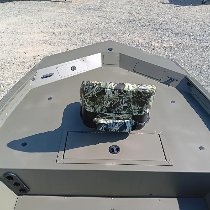 Slide: The Image of 2025 Tracker Grizzly 1754 SC boat interior with camo seat and storage compartment. - 4