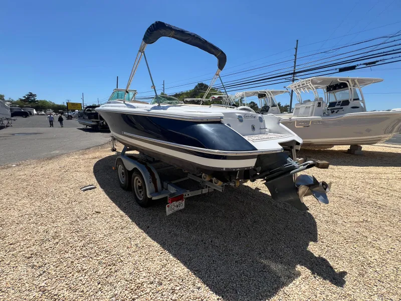 Slide: The Image of 2002 Chris-Craft 22 Launch Bow Rider on trailer, parked outdoors under clear blue sky. - 11