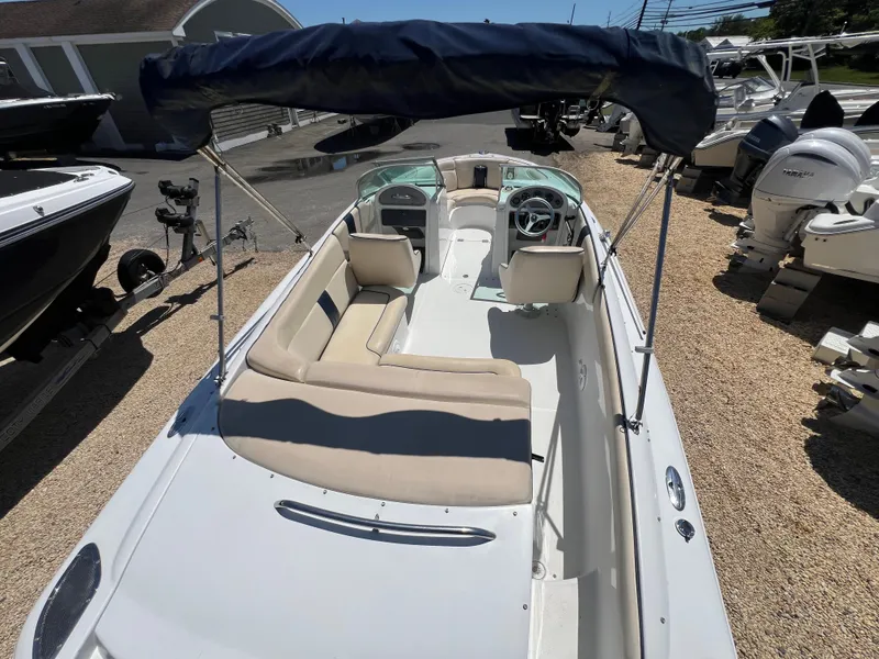 Slide: The Image of 2002 Chris-Craft 22 Launch Bow Rider with canopy, beige seating, and steering wheel. - 14