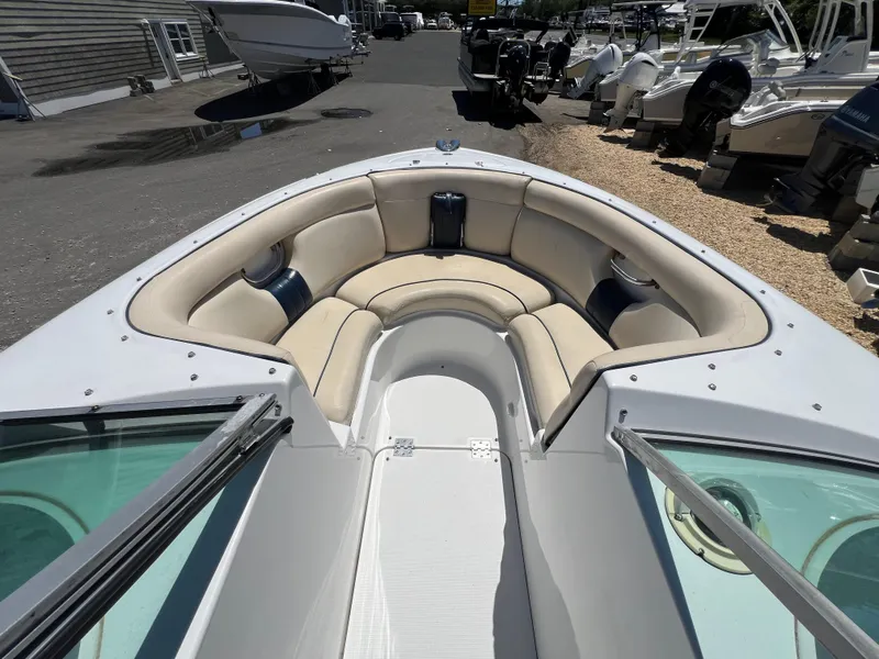 Slide: The Image of 2002 Chris-Craft 22 Launch Bow Rider with beige seating in a marina setting. - 15