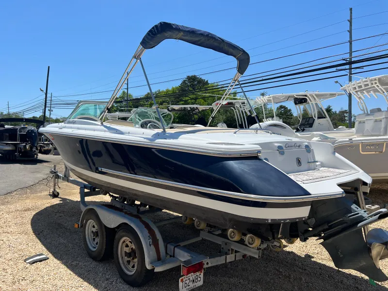 Slide: The Image of 2002 Chris-Craft 22 Launch Bow Rider on trailer, blue and white, parked outdoors. - 3