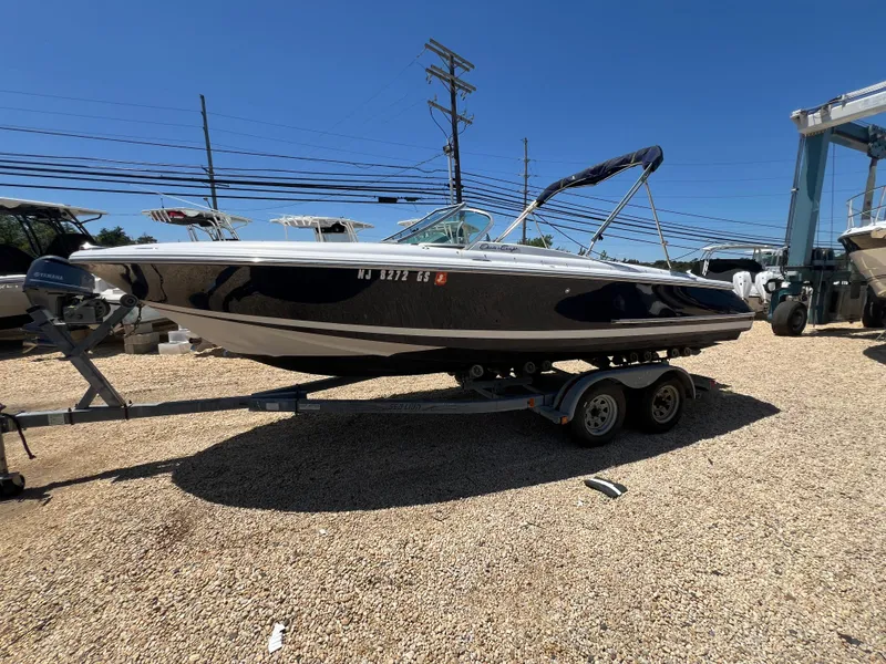 Slide: The Image of 2002 Chris-Craft 22 Launch Bow Rider on trailer, parked outdoors under clear blue sky. - 5