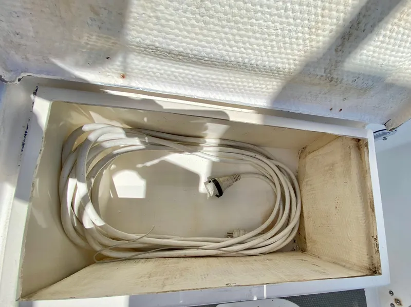 Slide: The Image of Coiled white cable inside a storage compartment on a 1979 Valiant 37 boat. - 15