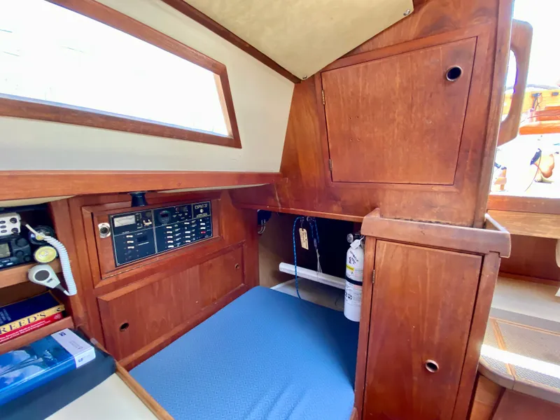 Slide: The Image of 1979 Valiant 37 sailboat interior with wooden cabinetry and navigation equipment. - 29