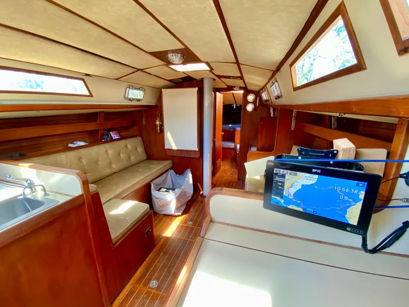 Slide: The Image of 1979 Valiant 37 yacht interior with wood finish, seating, and navigation equipment. - 33