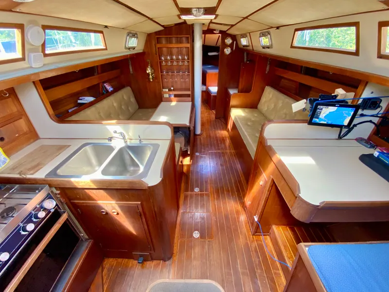 Slide: The Image of 1979 Valiant 37 yacht interior with wood finish, kitchen, seating, and navigation equipment. - 34