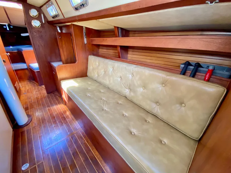 Slide: The Image of 1979 Valiant 37 yacht interior with beige seating and wooden flooring. - 38