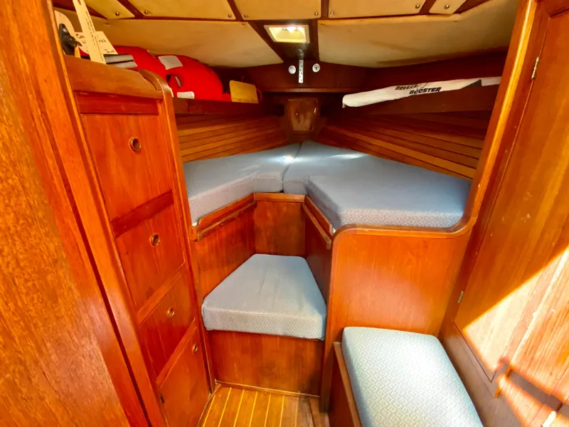 Slide: The Image of 1979 Valiant 37 sailboat cabin with wooden interior and blue cushions. - 46