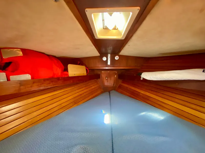 Slide: The Image of 1979 Valiant 37 sailboat cabin interior with wooden paneling and overhead light. - 47