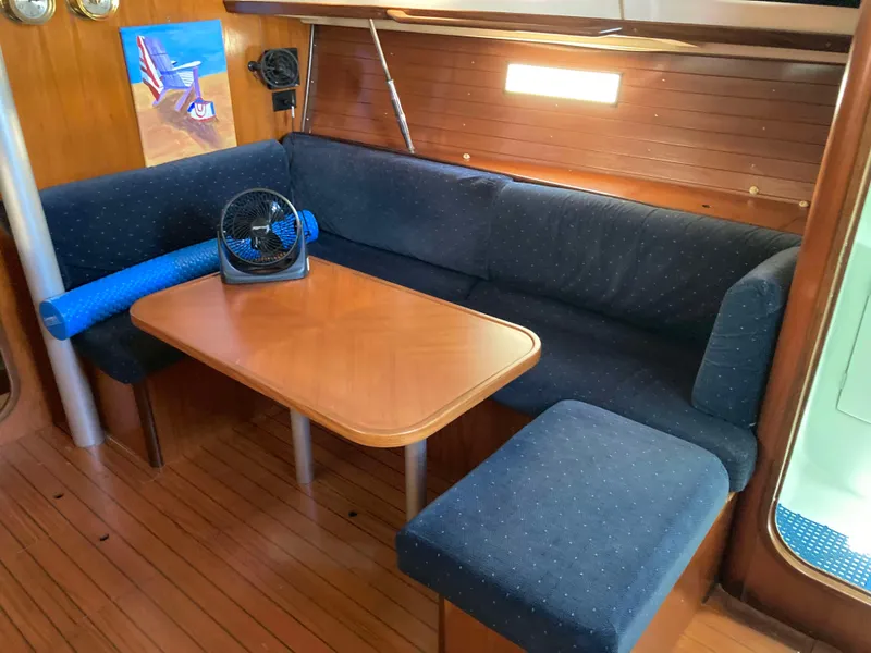 Slide: The Image of Cozy interior of 1993 Beneteau Oceanis 370 with blue seating and wooden table. - 14