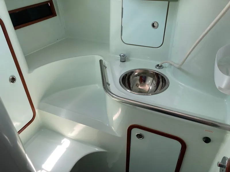 Slide: The Image of Interior of 1993 Beneteau Oceanis 370 sailboat, featuring a compact bathroom with sink and storage. - 19