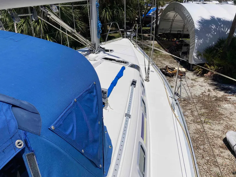 Slide: The Image of 1993 Beneteau Oceanis 370 sailboat with blue cover, docked outdoors. - 9