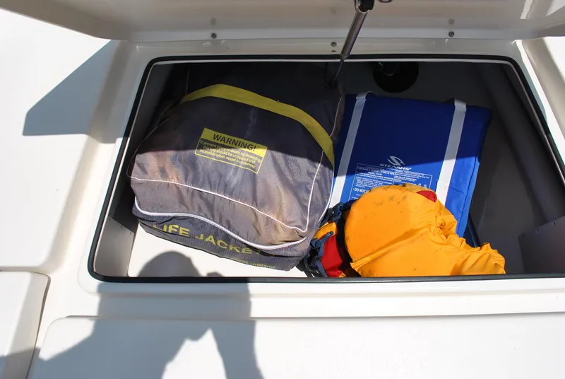 Slide: The Image of Storage compartment on a 2010 Pathfinder 2400 Tournament Edition boat with life jackets and gear. - 13