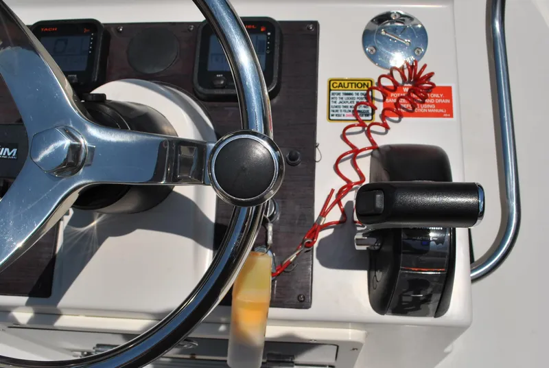 Slide: The Image of Steering wheel and controls of a 2010 Pathfinder 2400 Tournament Edition boat. - 22
