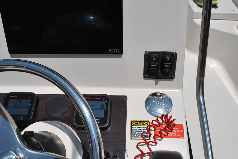 Slide: The Image of 2010 Pathfinder 2400 Tournament Edition boat dashboard with steering wheel and control panel. - 23