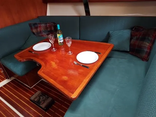 Slide: The Image of Cozy dining area in 1986 Pearson 36-2 sailboat with wooden table and teal seating. - 5
