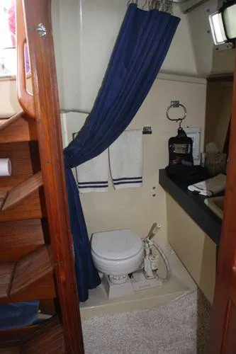 Slide: The Image of 1986 Pearson 36-2 yacht bathroom with blue curtain and compact toilet. - 6
