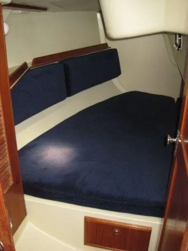 Slide: The Image of 1986 Pearson 36-2 sailboat cabin with blue cushions and wooden accents. - 8