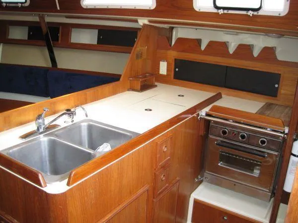 Slide: The Image of 1986 Pearson 36-2 yacht interior kitchen with wood cabinetry, sink, and stove. - 9
