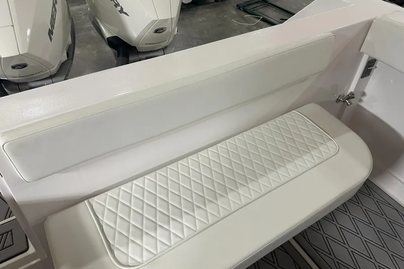 Slide: The Image of 2026 Hustler 288 CC boat interior with white quilted seating and Mercury engines. - 11