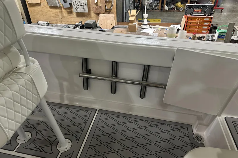 Slide: The Image of 2026 Hustler 288 CC boat interior with rod holders and diamond-patterned flooring. - 13