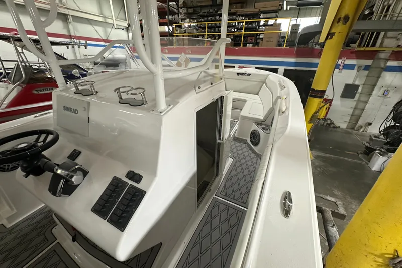 Slide: The Image of 2026 Hustler 288 CC boat interior with modern controls and seating in a workshop setting. - 15