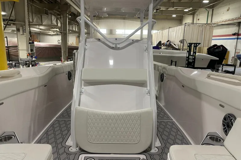 Slide: The Image of 2026 Hustler 288 CC boat interior with white seating and modern design in a showroom. - 18