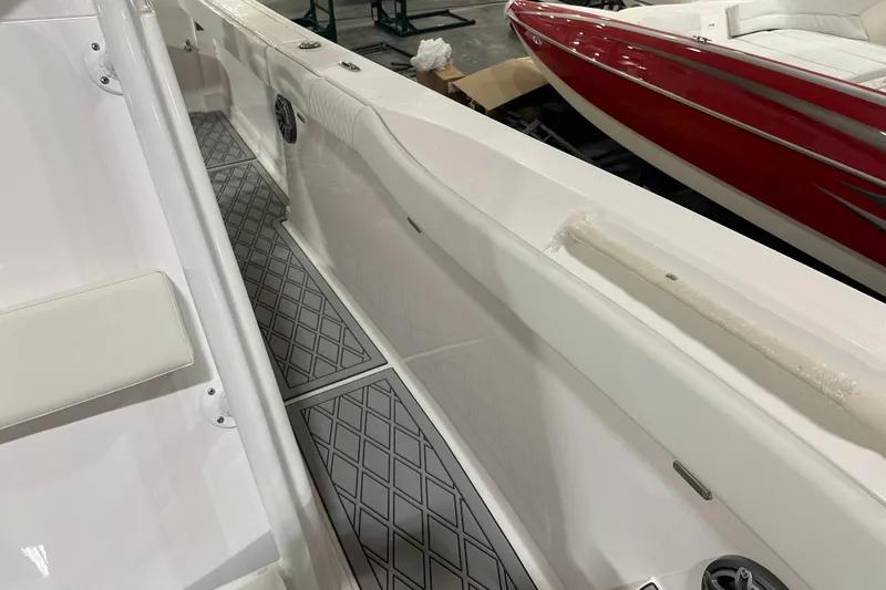 Slide: The Image of 2026 Hustler 288 CC boat interior with diamond-patterned flooring and sleek white design. - 23