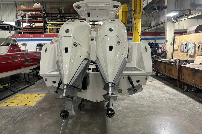 Slide: The Image of 2026 Hustler 288 CC boat with dual outboard engines in a workshop setting. - 4