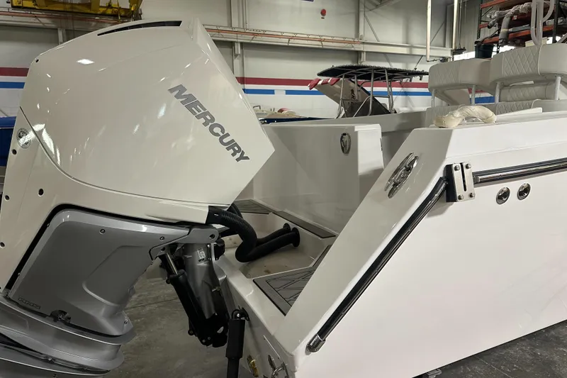 Slide: The Image of 2026 Hustler 288 CC boat with Mercury outboard motor in a warehouse setting. - 5