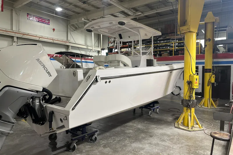 Slide: The Image of 2026 Hustler 288 CC boat in a workshop, featuring a powerful outboard motor. - 6