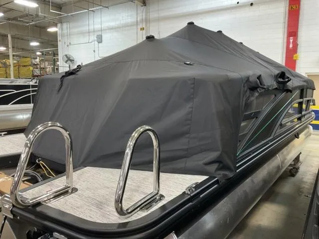 Slide: The Image of 2025 Bennington M Quad Bench 22 MFB pontoon boat with cover in a warehouse setting. - 15