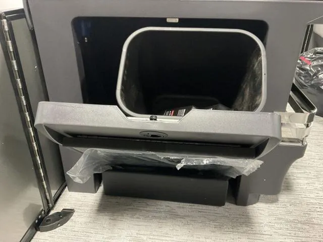 Slide: The Image of 2025 Bennington M Quad Bench 22 MFB storage compartment with open lid and plastic liner. - 18