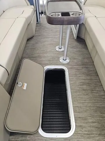 Slide: The Image of 2025 Godfrey Sweetwater 2486 SFL pontoon interior with open storage compartment and table. - 11