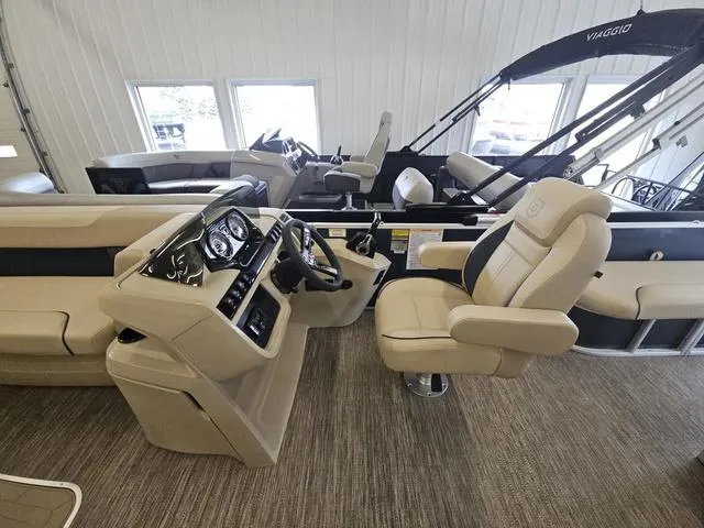 Slide: The Image of 2025 Godfrey Pontoons Sweetwater 2486 SFL GTP interior with beige seating and modern dashboard. - 9