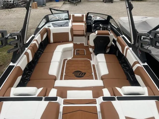 Slide: The Image of 2025 Malibu 23 MXZ boat interior with brown and white seating, spacious layout. - 3