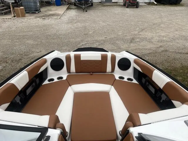 Slide: The Image of 2025 Malibu 23 MXZ boat interior with brown and white seating, featuring built-in speakers. - 4