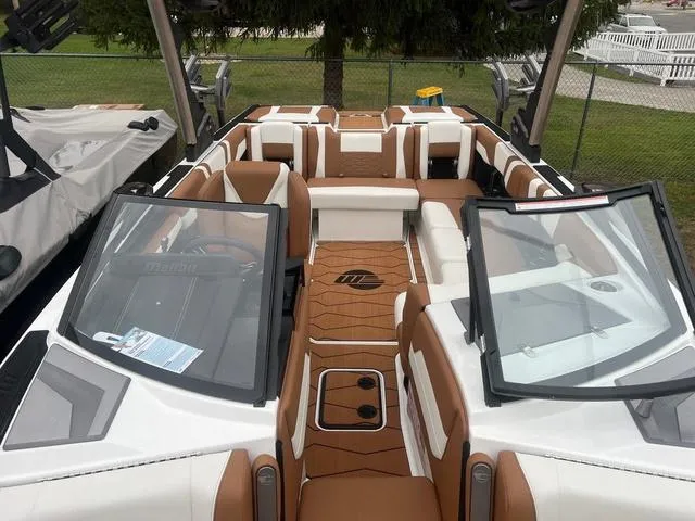 Slide: The Image of 2025 Malibu 23 MXZ boat interior with brown and white seating, open windshield, and modern design. - 5