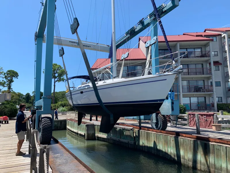 Slide: The Image of Catalina 36 sailboat from 2002 being lifted by a crane at a marina. - 1