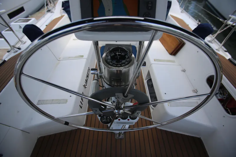 Slide: The Image of Steering wheel of 2002 Catalina 36 sailboat with compass, wooden deck, and cockpit seating. - 2